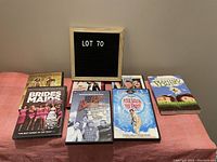 Photo showing six DVD cases arranged on a table against a plain wall including Bridesmaids, Blazing Saddles, The Party, and others.