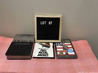 Overview photo showing Lot 67 sign with all three DVD cases: Band of Brothers, Full Metal Jacket, Patton