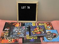 Photo showing 9 assorted music CDs including Big Shiny Tunes 3 in box set, Big Shiny Tunes 5, Dance 1997, Now 3, and others.