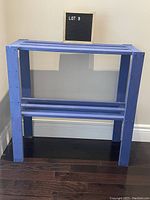 Blue painted pine shelf front view showing entire structure with slatted top and bottom shelf