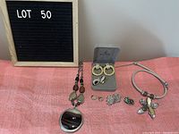 Photo showing the full lot of costume jewelry including necklaces, clip-on earrings, and ring.