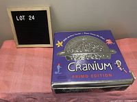 Photo of Cranium Primo Edition board game box with purple background and silver embossed brain helmet design.