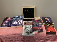 Overview of the five ghost story books arranged on a pink cloth with a sign stating LOT 83.