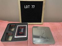 Tin box opened to show two shot glasses and deck of cards inside foam insert.