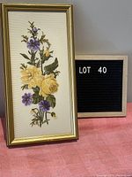Front view of framed petit point embroidery with yellow and purple flowers, showing overall design and frame.