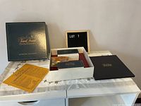 Full layout of the game components including box, cards, scoring pieces, and instructions on a white surface.