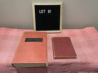 Two vintage hardcover books on pink cloth surface, larger Winston Churchill book and smaller reddish book.