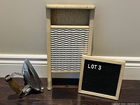 Photo showing both the vintage wooden washboard with metal scrubbing surface and vintage Singer iron with wooden handle.
