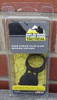 Front of original blister packaging showing Butler Creek Tactical branding and product name with a visible polymer scope cover inside.