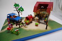Playmobil Country Riding Yard model 84771 farm scene assembled with barn, horses, wagon, blue truck, figurines and accessories on green base
