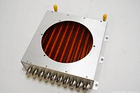 Top view of the heat exchanger showing the copper coil inside the metallic housing with a circular opening.