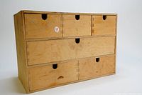 Front view of the wooden drawer unit showing six drawers and minor wear marks.