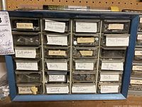 Photo of the first small organizer with compartments labeled for various small screws, bolts, nuts, and miscellaneous hardware items such as train parts and craft washers.