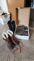 Three pairs of boots including brown Sorel insulated with fur lining and red laces, black ProLine mid-calf rubber boots, and black Genfoot slip-resistant steel toe boots in original box.