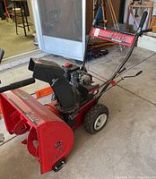 Side profile of the snowblower showing auger housing and chute