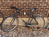 Full side view of Sedona Giant bicycle showing black frame, front and rear wheels with knobby tires, rear cargo rack, and saddle.