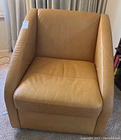 Front view of tan leather swivel chair showing cushion and armrests.