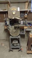 Full view of vintage Delta 14-inch band saw with metal base positioned in a workshop environment.