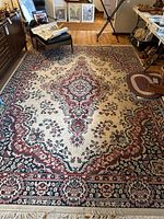 Full view of the large area rug displaying traditional floral medallion pattern and fringed edges in a domestic setting.