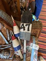 Photo showing two wooden painted buoys and one weathered wood wall art piece with number '47'.
