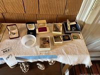 Overview of entire jewelry lot laid out on a white towel showing multiple boxes and cases
