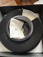 Top view of a circular Kodak slide tray holding slides with some papers inside the tray.