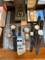 Multiple watches arranged on wooden surface including boxed Precision and Pulsar watches and loose watches