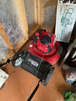 Red Craftsman push mower with black side discharge grass catcher attached.