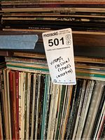 Close-up of vinyl record spines with MaxSold tag visible