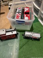 Overview of four train cars stored in plastic bin