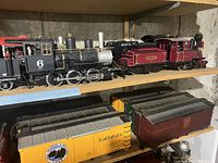 Top two shelves showing three steam locomotives with tenders and one boxcar