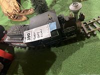 Side view of locomotive and tender on black track, showing “Helena” lettering and coal load