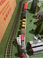 The full length of the locomotive and attached carts on the track, showing logs and various cars.