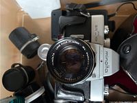 Silver and black Minolta camera with MC Rokkor 55mm f1.7 lens, visible lens branding, camera in partial leather case