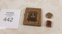 Antique framed photo with two photo lockets placed on table
