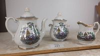Full view of the three-piece antique Robert Cochran Pekin pattern tea set showing teapot, creamer, and sugar bowl on a table.