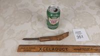 Overall view showing full length of crooked cutter with scale (Canada Dry can and wooden ruler)
