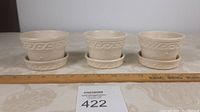 All three McCoy flower pots with matching saucers arranged in a row next to a ruler showing about 4 inches width each.