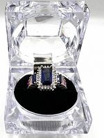 Ring displayed inside clear acrylic box on black cushion