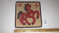 Full view of the 12 x 12 inch hooked mat showing the red horse design with surrounding floral motifs and a measuring scale.