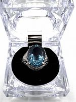 Ring displayed in clear acrylic box on black cushion