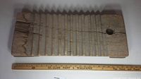 Top view of wooden scrub board with full length visible beside a measuring ruler showing length around 24 inches.