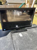 Front view of the 32-inch flat screen television showing screen and stand, placed outdoors.