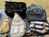 Photo showing the lot of five bags on a table: black tote, black briefcase, striped handbag, beige backpack, cream polka dot sling bag