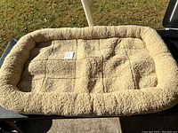 Top-down image showing full rectangular extra large pet bed with beige sherpa fleece fabric and a cushioned outer edge.