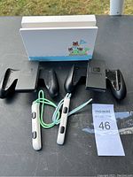 View of all Nintendo Switch accessories including two black Joy-Con grips, two white wrist straps with green lanyards, and an Animal Crossing themed dock.