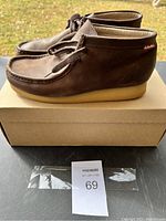 Side view of a single brown leather Clarks shoe on a box outdoors