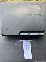 Top view of the Sony PlayStation 3 console showing the PS3 logo on the matte surface with some dust/weathering visible.
