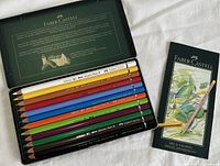 Set of twelve Faber Castell Albrecht Durer watercolor pencils arranged in metal tin with detailed branding inside lid.