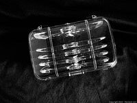 Clear plastic storage case housing multiple interchangeable magnifying lenses for the headband set.